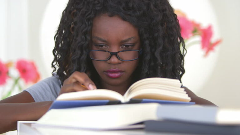 Black woman with glass reading a book