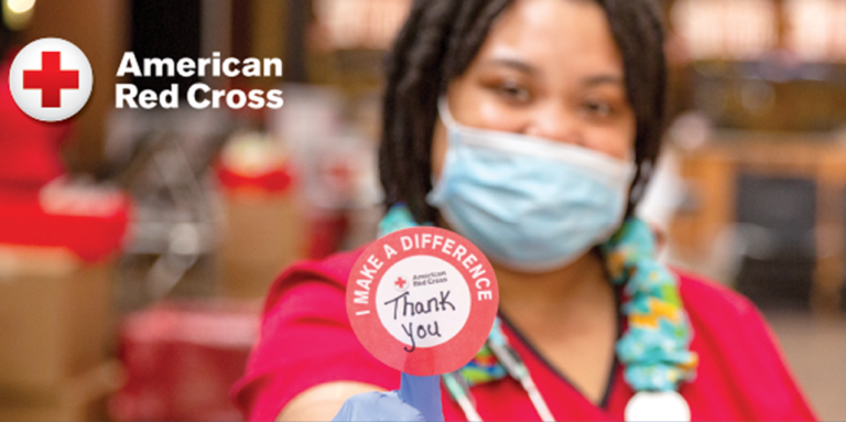 Red Cross worker holding a thank you sticker