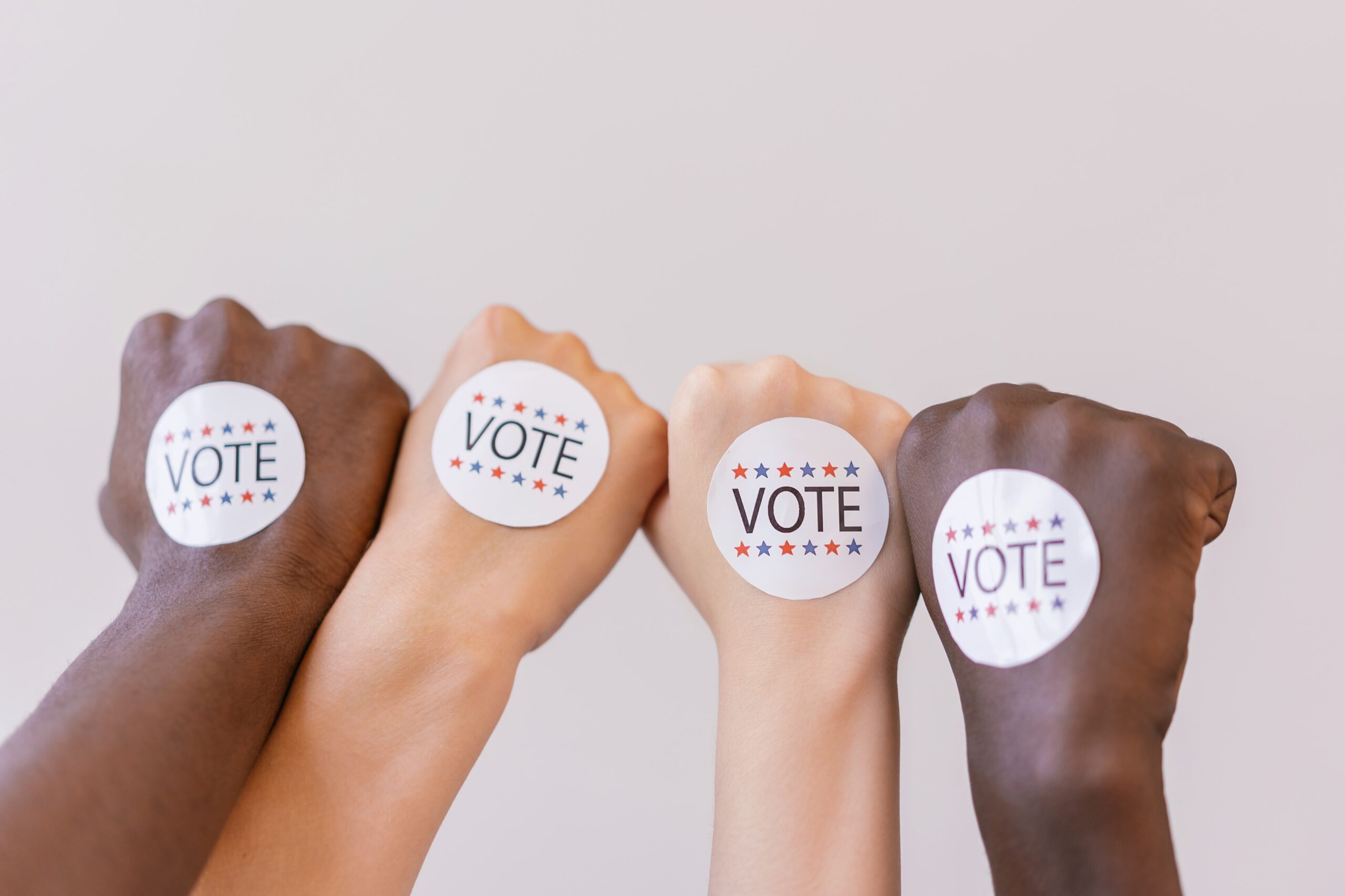 hands with a Vote sticker on it